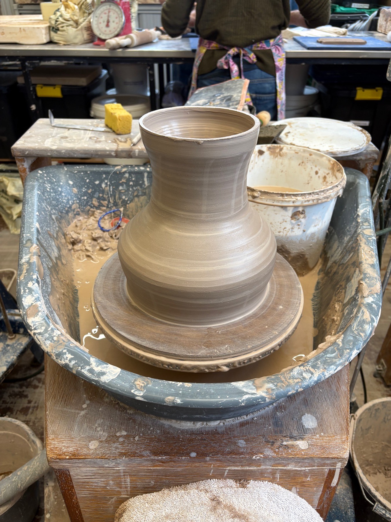 A ceramic drum form being thrown on the wheel